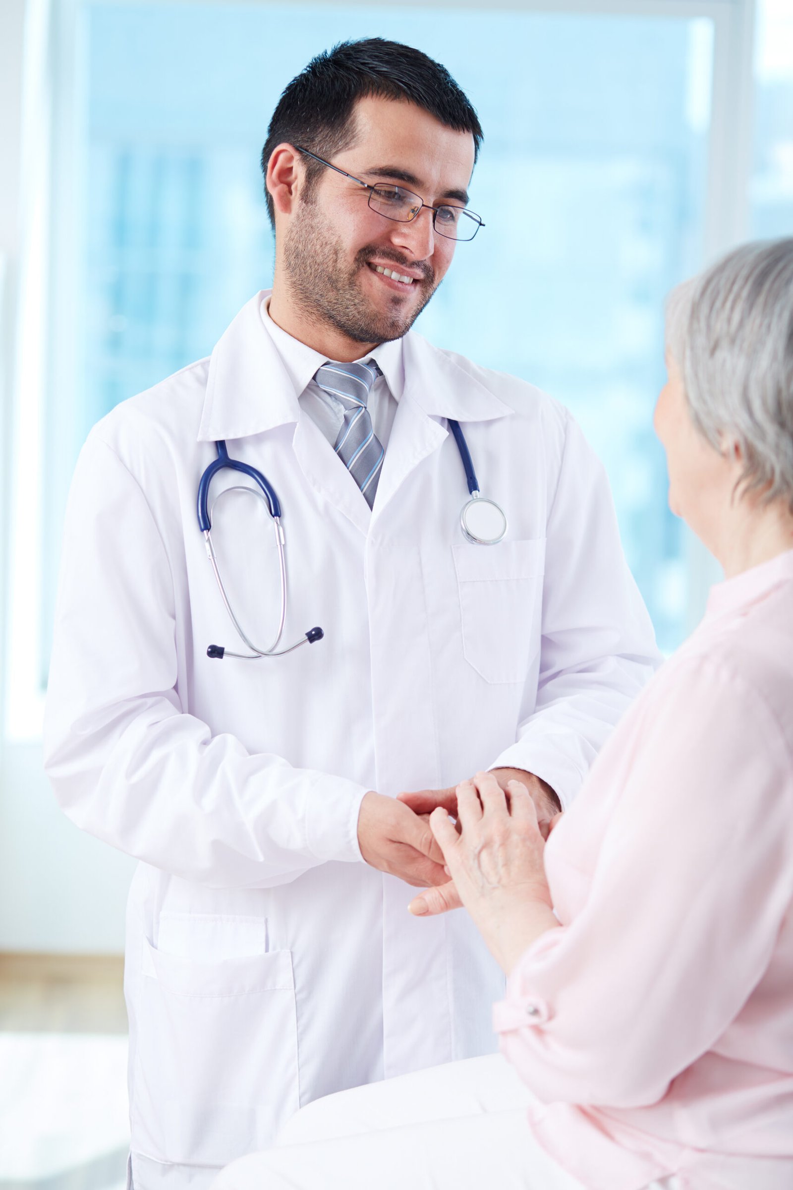 Confident doctor looking at his senior patient while speaking to her